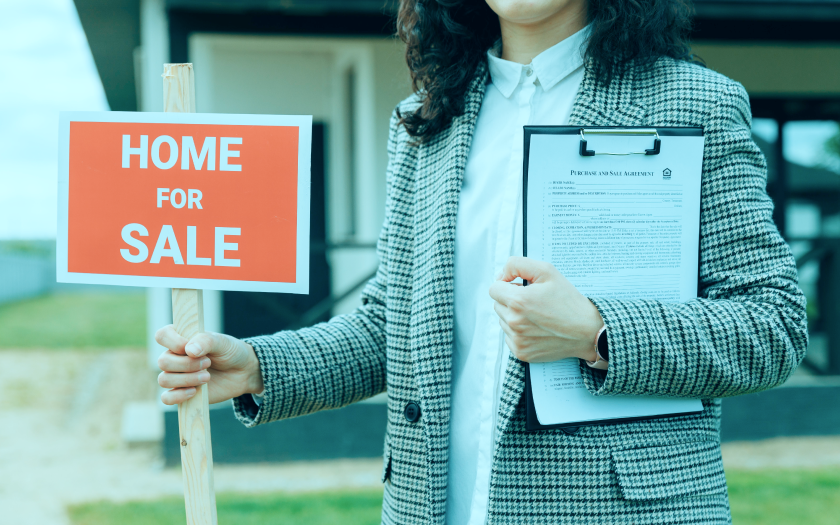 Real Estate Agent holding a sign